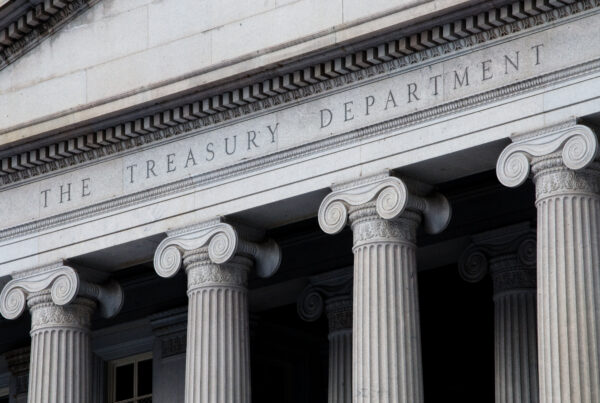 facade of the US Treasury building, with four columns underneath the title